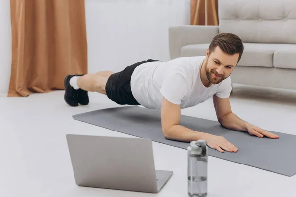 Training Hause Sportlicher Mann Der Yoga Planke Macht Während Online — Stockfoto