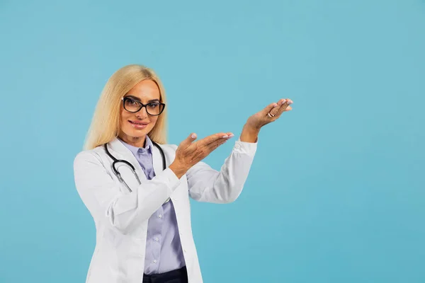 Ώριμη Γυναίκα Γιατρός Γυαλιά Στηθοσκόπιο Κρατώντας Φάκελο Και Δείξει Χέρι — Φωτογραφία Αρχείου