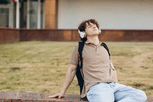Concept of e-learning, distance study or remote learning concept, Young happy curly hair school guy, college or university student with backpack and headphones
