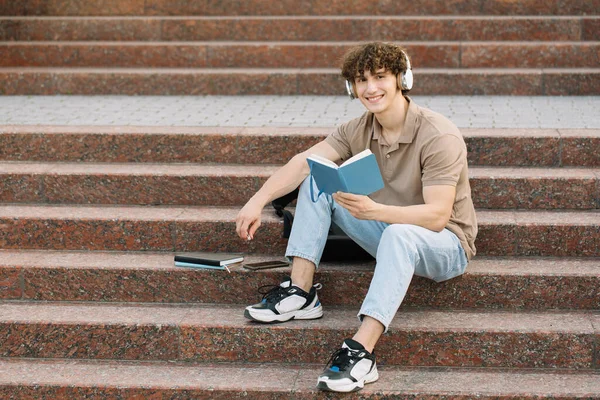 Çekici Erkek Öğrenci Üniversitenin Merdivenlerinde Oturur Bir Şeyler Okur Sınavlara — Stok fotoğraf