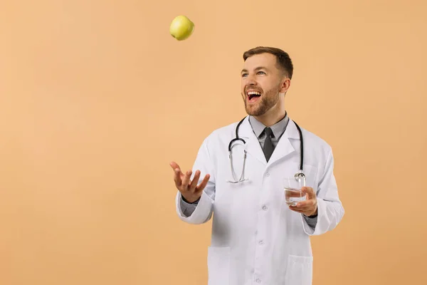 Médico Nutricionista Masculino Con Estetoscopio Sonriendo Sosteniendo Agua Manzana Sobre — Foto de Stock