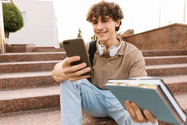 Ελκυστικά Σγουρά Μαλλιά Νεαρός Άνδρας Πανεπιστήμιο Φοιτητής Κάθεται Στις Σκάλες — Φωτογραφία Αρχείου