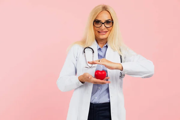 Médico Mulher Madura Óculos Com Estetoscópio Segurando Coração Fundo Rosa — Fotografia de Stock