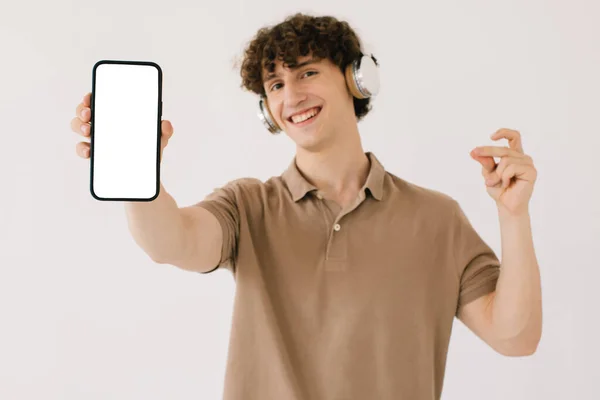 Retrato Jovem Atraente Fones Ouvido Segurando Smartphone Com Tela Branca — Fotografia de Stock
