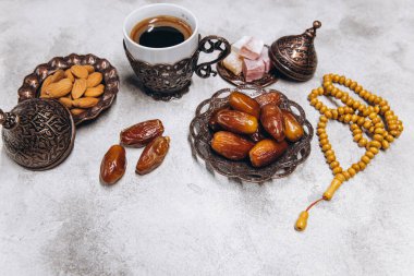Ramazan Kareem 'in masa üstü görüntüsü. Gri taştan arka planda meyve, kahve ve badem var. Kopyalama alanı olan düz.