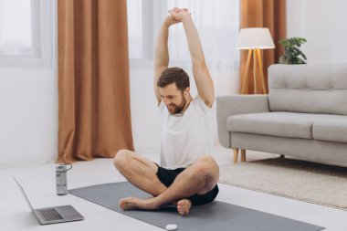 Karantinada sakin olun. Millennial elemanı antrenörle internetten laptopla meditasyon yapıyor. Boş alan.