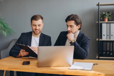 İş ekibi çalışması. Laptopta birlikte çalışan iki şirket işadamı.