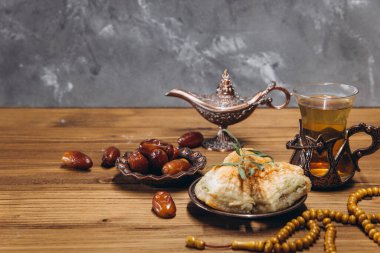 Ramazan konsepti, bir fincan çay, bir tabak tatlı hurma ve baklava, kopyalama alanı