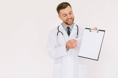 Dosyası olan mutlu erkek doktor, beyaz arka planda fotokopi odasında bir şey gösteriyor.