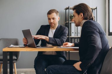 Ciddi bir iş adamı sözleşme detaylarını tartışıyor ya da modern ofisteki yetenekli finans danışmanıyla sorunların çözümünü buluyor. İki başarılı erkek partner toplantı odasında proje görüşmeleri.