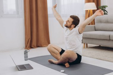 Karantinada sakin olun. Millennial elemanı antrenörle internetten laptopla meditasyon yapıyor. Boş alan.