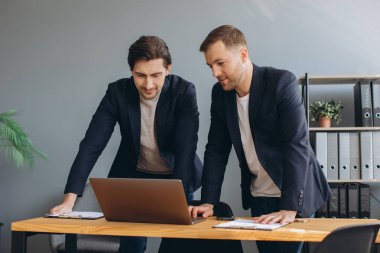 İş ekibi çalışması. Laptopta birlikte çalışan iki şirket işadamı.