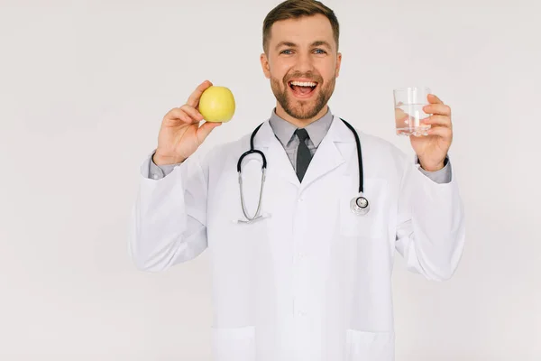 Médico Nutricionista Masculino Feliz Con Estetoscopio Sonriendo Sosteniendo Agua Manzana — Foto de Stock