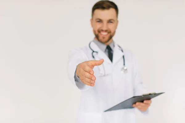 聴診器とフォルダを持つ幸せな医者は白い背景に挨拶の手を伸ばし — ストック写真