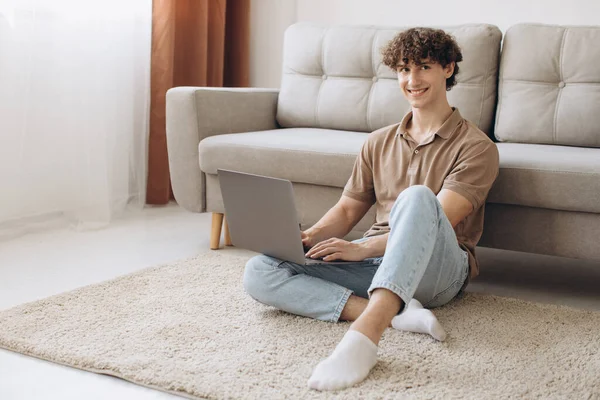 Retrato Atraente Jovem Cabelo Encaracolado Homem Usando Laptop Enquanto Sentado — Fotografia de Stock