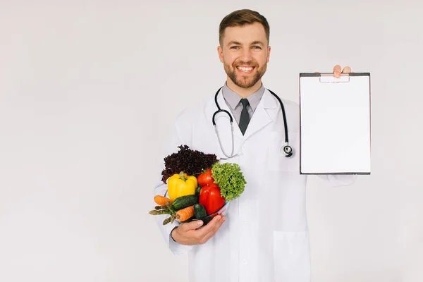 Αρσενικός Διατροφολόγος Γιατρός Στηθοσκόπιο Που Κρατάει Φρέσκα Λαχανικά Και Φάκελο — Φωτογραφία Αρχείου