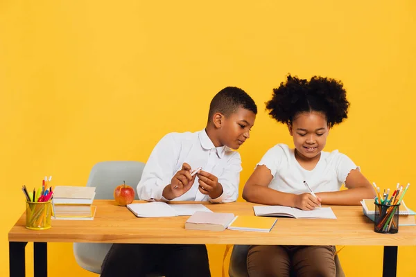 Boldog Afro Amerikai Iskoláslányt Iskolásfiút Akik Együtt Ülnek Asztalnál Sárga — Stock Fotó