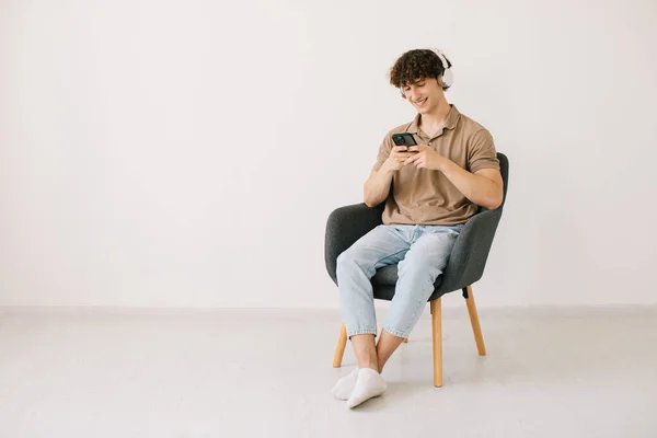 Atractivo Joven Usando Ordenador Portátil Usando Auriculares Mientras Está Sentado — Foto de Stock