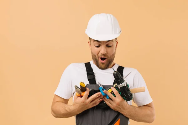 Positive Männliche Reparaturkraft Hause Mit Verschiedenen Reparaturwerkzeugen Auf Beigem Hintergrund — Stockfoto