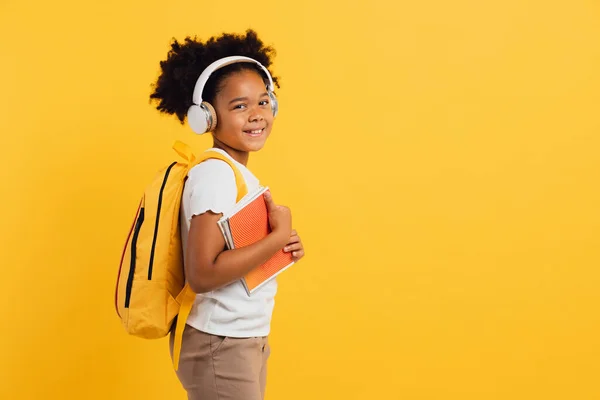 Boldog Afro Amerikai Iskolás Lány Fülhallgató Hátizsák Kezében Notebook Sárga — Stock Fotó