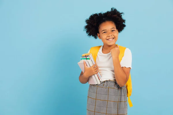 Stock image Happy African American schoolgirl pointing cool on blue background, back to school concept.