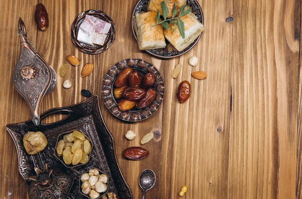 木のテーブルの上で乾燥した日付とお茶 アラビアの伝統的な料理 鍋や日付果物 ラマダーン カレームEid Mubarakの概念 最上階だ 平置きだ スペースのコピー — ストック写真