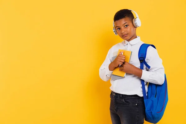 ヘッドフォンやバックパックを持って幸せな混合レースの学校の少年は 本やノートブックを保持 学校のコンセプトに戻る — ストック写真