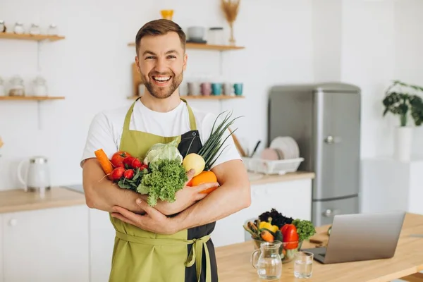 Evdeki Mutfakta Farklı Taze Sebzeler Tutan Mutlu Bir Adam — Stok fotoğraf