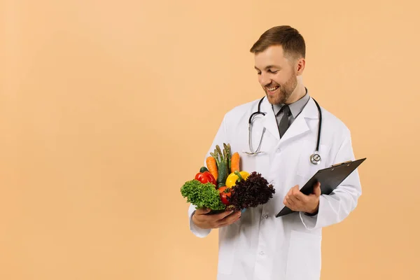 Médico Nutricionista Masculino Con Estetoscopio Sosteniendo Verduras Frescas Sobre Fondo — Foto de Stock