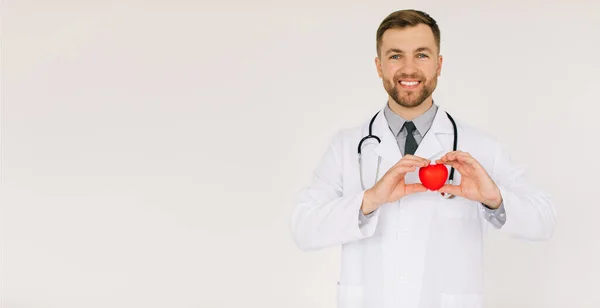 Der Glückliche Männliche Kardiologe Mit Herz Und Kopierraum Auf Weißem — Stockfoto