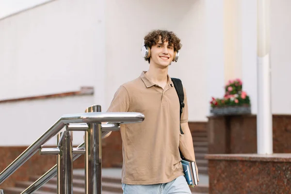 Çekici Kıvırcık Saçlı Kulaklıklı Üniversite Kampüste Yürüyen Üniversite Öğrencisi — Stok fotoğraf