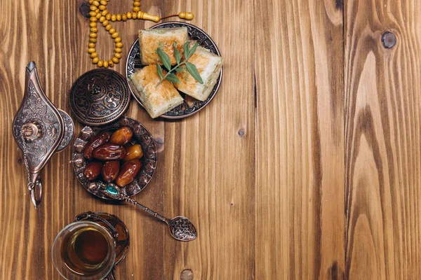 Ramazan konsepti, bir fincan çay, bir tabak tatlı hurma ve baklava, fotokopi alanı, üst manzara