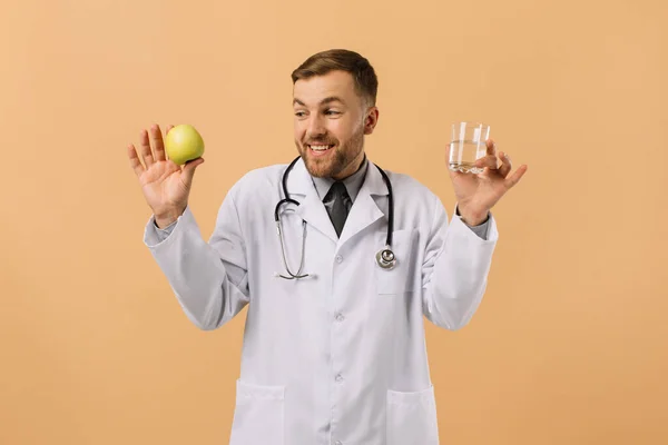 Médico Nutricionista Masculino Con Estetoscopio Sonriendo Sosteniendo Agua Manzana Sobre — Foto de Stock