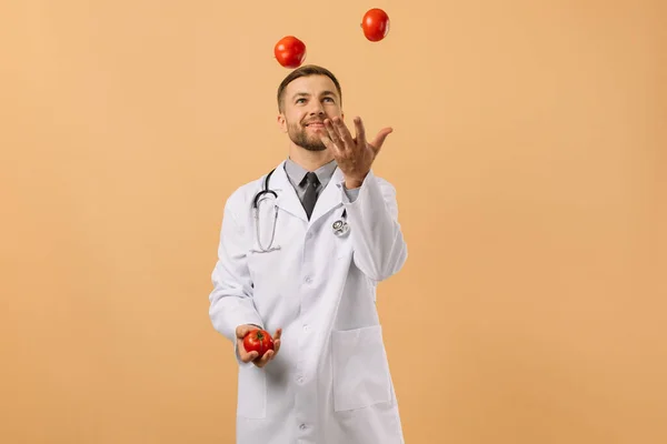 Médecin Nutritionniste Masculin Avec Stéthoscope Souriant Jonglant Tomates Sur Fond — Photo