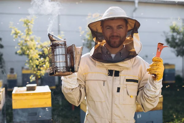 ミツバチの巣の近くの養蜂場で働く幸せなオスの養蜂家の肖像画 蜂蜜を集めろ 養蜂家の仕事だ 養蜂の概念 — ストック写真