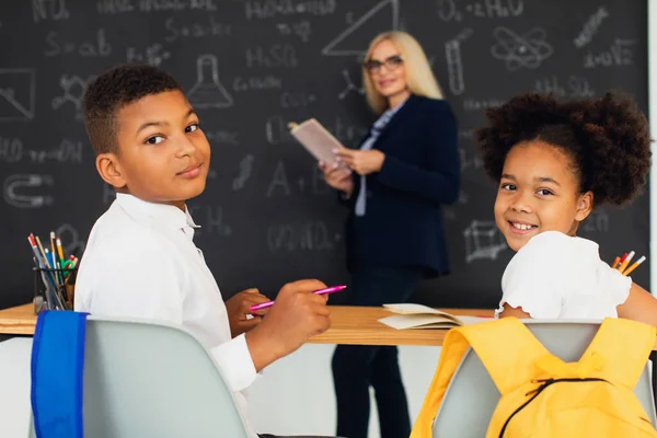 1人の少女と1人の少年 アフリカ系アメリカ人の学校の子供は 授業中に教師との問題を解決する 学校に戻る — ストック写真