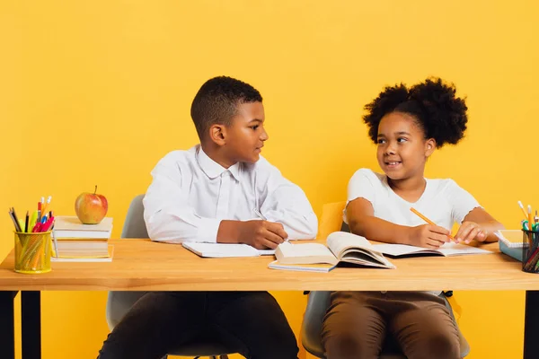 Šťastná Africká Americká Školačka Školák Sedí Spolu Stolem Studují Žlutém — Stock fotografie