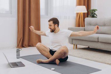 Karantinada sakin olun. Millennial elemanı antrenörle internetten laptopla meditasyon yapıyor. Boş alan.