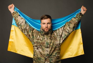 Ukrayna bayrağını taşıyan cesur bir Ukraynalı askerin portresi, özgürlük kavramı.