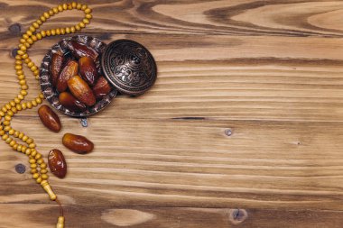 Dekorasyonun masa üstü görüntüsü Ramazan Kareem, ahşap zemin üzerinde meyve ve tespih taşları. Kopyalama alanı olan düz.