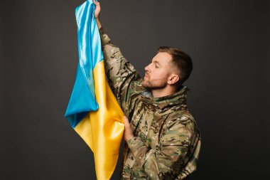Ukrayna bayrağını taşıyan cesur bir Ukraynalı askerin portresi, özgürlük kavramı.