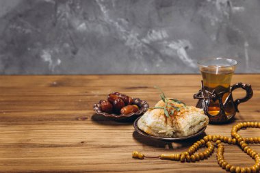 Ramazan konsepti, bir fincan çay, bir tabak tatlı hurma ve baklava, kopyalama alanı