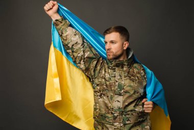 Ukrayna bayrağını taşıyan cesur bir Ukraynalı askerin portresi, özgürlük kavramı.