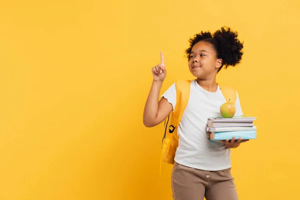Африканська Американська Школярка Тримає Зошити Книжки Показує Щось Жовтому Фоні — стокове фото