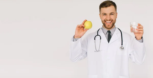 Szczęśliwy Lekarz Dietetyk Stetoskopem Uśmiechając Się Trzymając Wodę Jabłko Białym — Zdjęcie stockowe