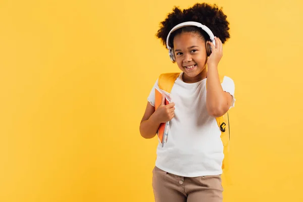 Щаслива Афроамериканська Школярка Навушниках Рюкзаком Зошитами Жовтому Тлі Копіюйте Простір — стокове фото