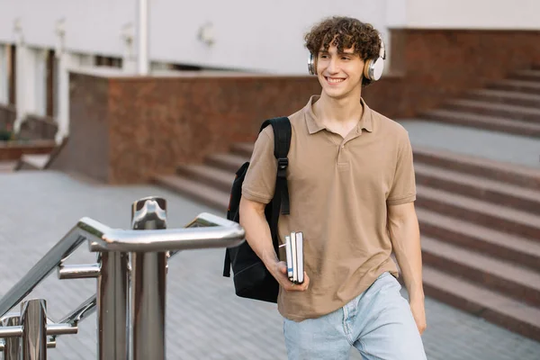 Çekici Kıvırcık Saçlı Kulaklıklı Üniversite Kampüste Yürüyen Üniversite Öğrencisi — Stok fotoğraf