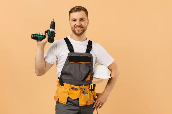 Positive Männliche Reparaturkraft Hause Mit Einem Schraubendreher Auf Beigem Hintergrund — Stockfoto