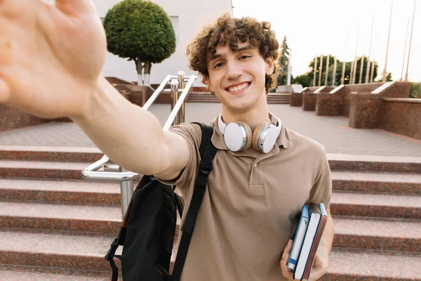 Kulaklıklı Çekici Kıvırcık Erkek Öğrencinin Portresi Gülümseyen Selfie Çeken Video — Stok fotoğraf