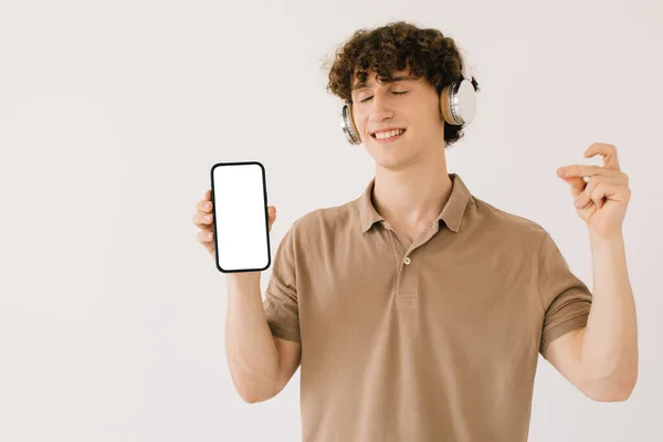 Πορτρέτο Του Ελκυστική Νεαρός Άνδρας Ακουστικά Που Κατέχουν Smartphone Λευκή — Φωτογραφία Αρχείου